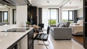 A modern apartment with a kitchen, dining area, and living room. - Aristo 1BR Coastal Escape in Surin Beach (Tambon Choeng Thale)