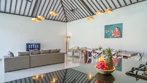 Ein modernes Wohnzimmer mit einer Couch, einem Esstisch und Kunstwerken an der Wand.