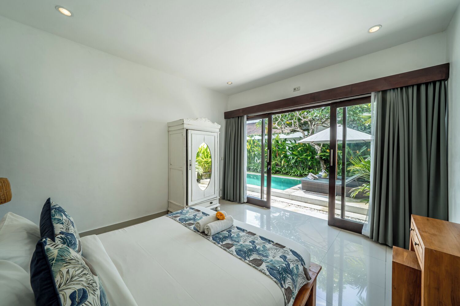 Un dormitorio con una cama grande, un armario y vistas a una piscina.