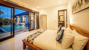 Ein Schlafzimmer mit Bett, Nachttisch, Spiegel, Kleiderschrank und Blick auf ein Freibad.