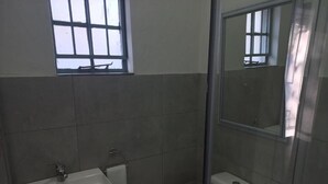 A bathroom with a sink, toilet, and a shower enclosure. - Triple9 Guesthouse (Hatfield, Pretoria)