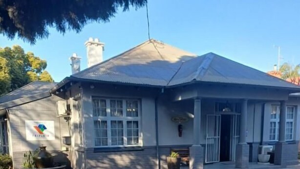 A building with a tiled roof, a chimney, and a paved entrance area. - Triple9 Guesthouse (Hatfield, Pretoria)