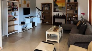 Ein Wohnzimmer mit einer Couch, einem Couchtisch und Bücherregalen.