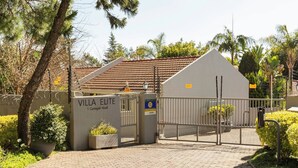 A gated entrance to a villa with a sign reading 'VILLA ELITE 1 Cadogan Road.' - Rosario’s Village 2 Bed Unit 09 Bryanston (Sandton)