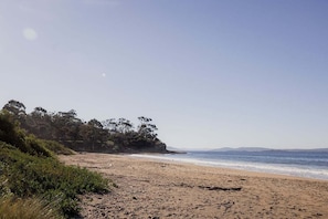A beach with a clear sky, sandy shore, and trees. - Classic Beauty by The Bay - family firepit retreat (Kingborough)