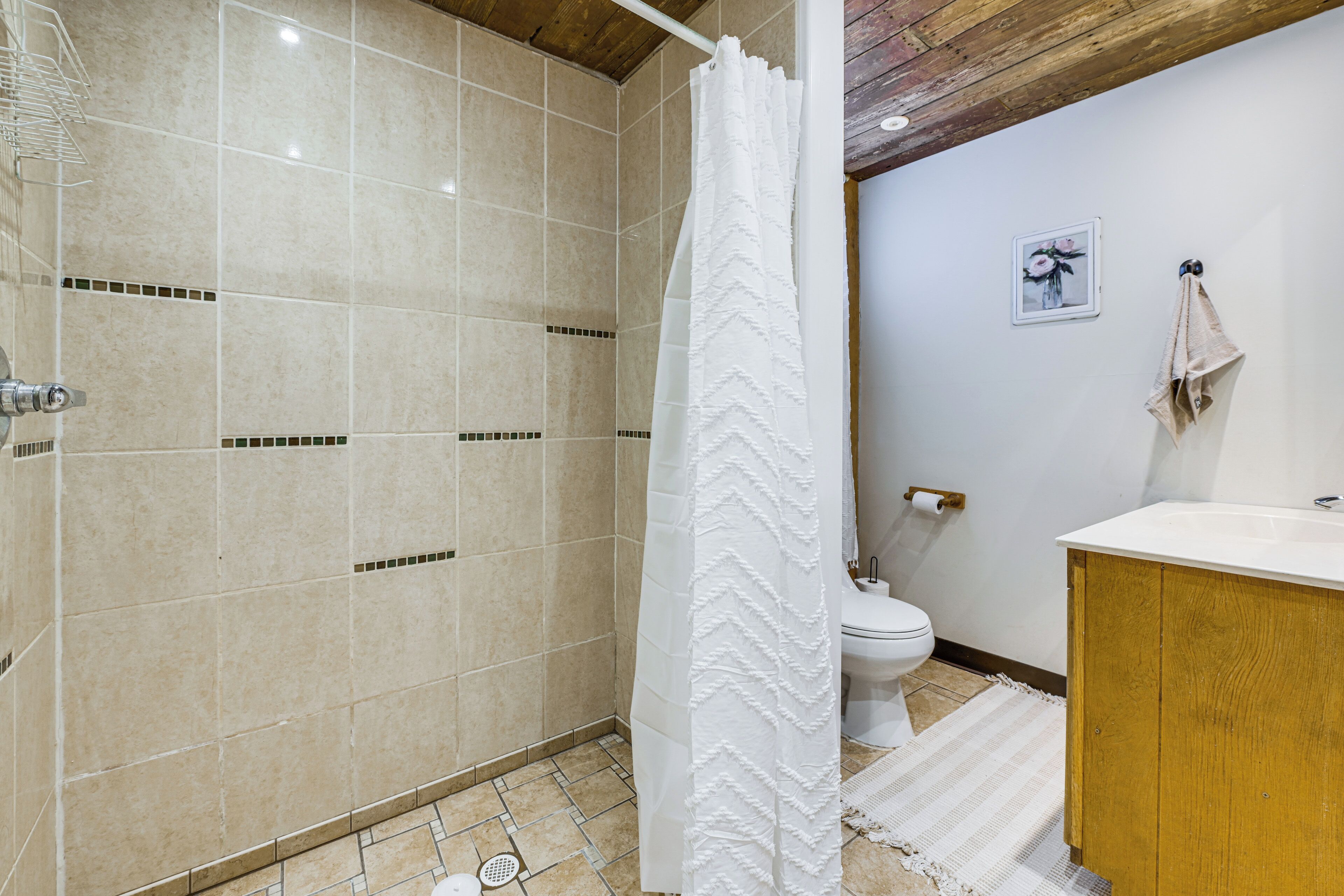 A bathroom with a shower, toilet, and sink.