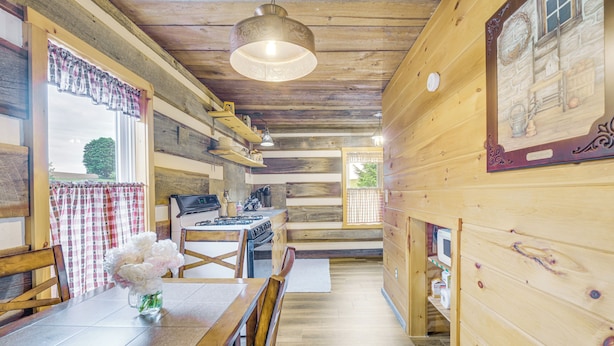 Ein Holzinterieur mit Esstisch, Stühlen, Küchenzeile und Holzboden.
