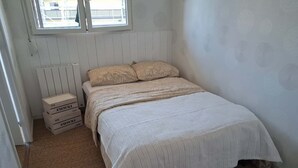 Ein Schlafzimmer mit einem Bett, einem Heizkörper und Aufbewahrungsboxen.