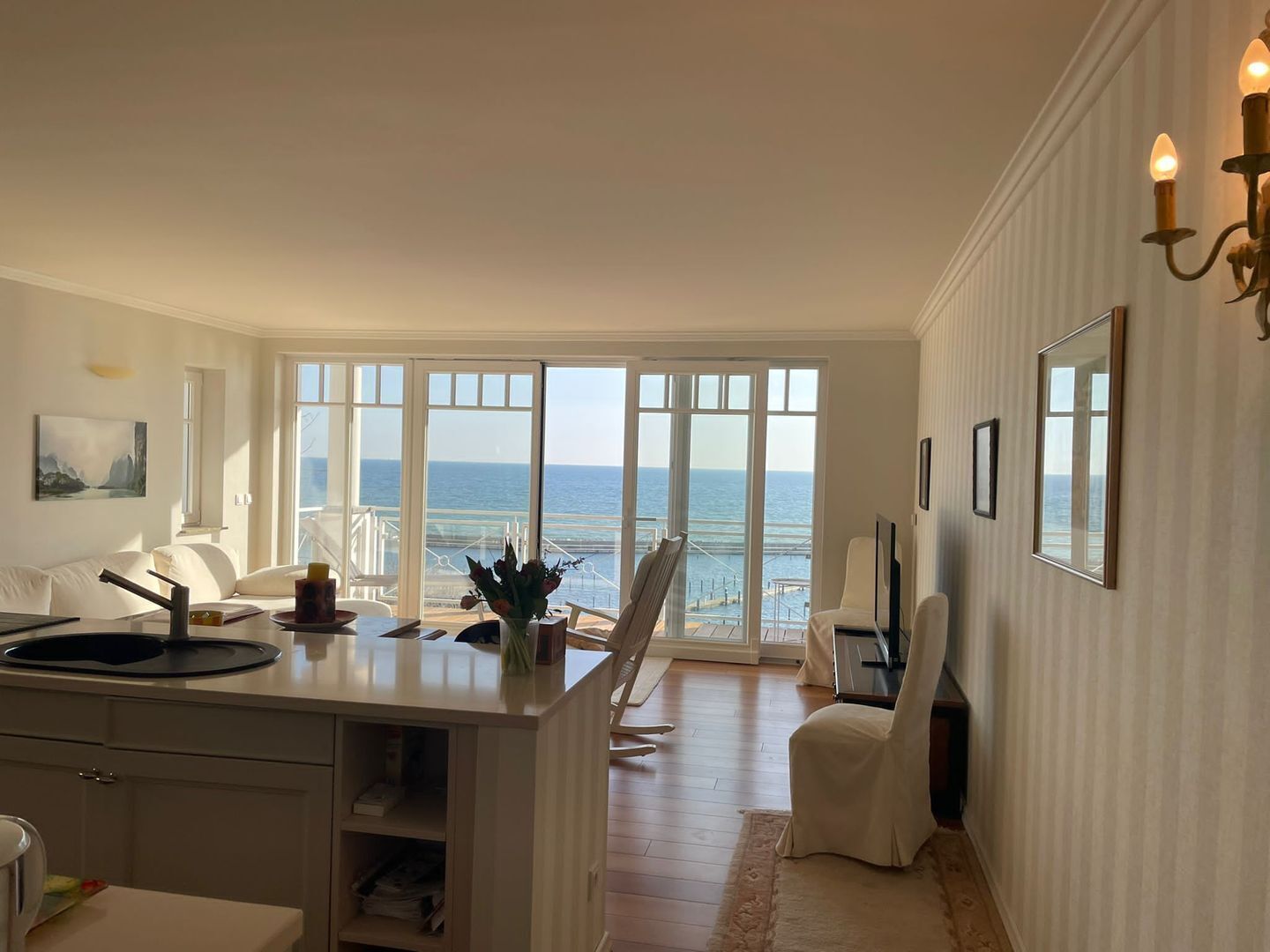 Une pièce spacieuse dotée d’une grande fenêtre donnant sur la mer, d’un coin repas et d’un espace salon avec vue.