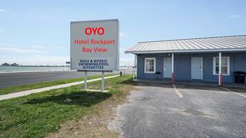 Señal para el Hotel OYO Rockport Bay View, indicando disponibilidad de piscina diaria y semanal, así como kitchenette.