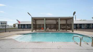 A swimming pool with a wooden deck area, a covered seating area, and a sign for 'Seaview.'