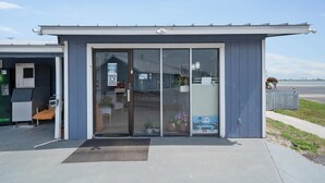 A building with a glass door entrance, a small bench outside, and a clear sky.