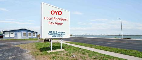 Señal para el Hotel OYO Rockport Bay View, indicando piscina diaria y semanal, además de kitchenette.