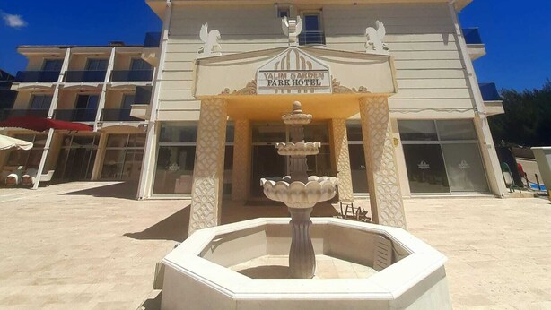 A building with a sign reading 'Yalin Garden Park Hotel' and a fountain in front. - Yalim Garden Park Otel (Sivasli)