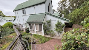 A two-story house with a green roof, a brick pathway, and a metal railing. - Mollymook Beach Townhouse on the Hilltop Golf Course and minutes to the beach (Mollymook Beach)