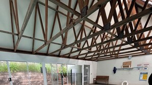 An indoor swimming pool with a wooden ceiling, glass doors leading outside, and a bench near the pool. - Mollymook Beach Townhouse on the Hilltop Golf Course and minutes to the beach (Mollymook Beach)