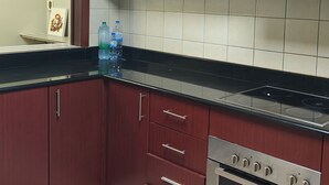 A kitchen with dark wooden cabinets, a stainless steel oven, and a tiled backsplash.
