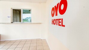 A reception area with a window, a counter, and a wall with 'OYO HOTEL' signage.