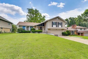 A two-story house with a front yard, a garage, and a chimney. - Kansas City Extended Stay Near Stadiums & Downtown (Kansas City)