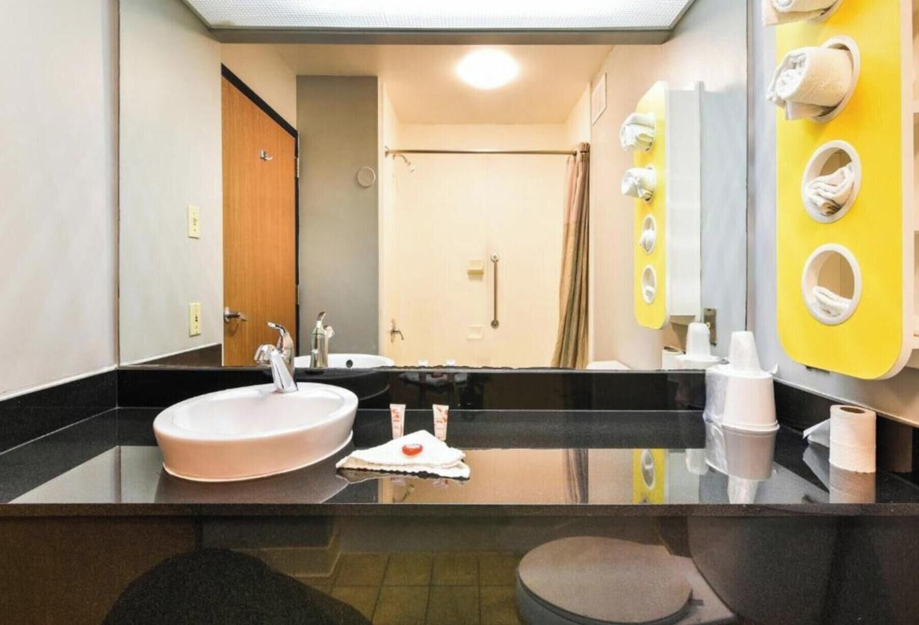 Ein Badezimmer mit zwei Waschbecken, einem Spiegel und einer Duschkabine.