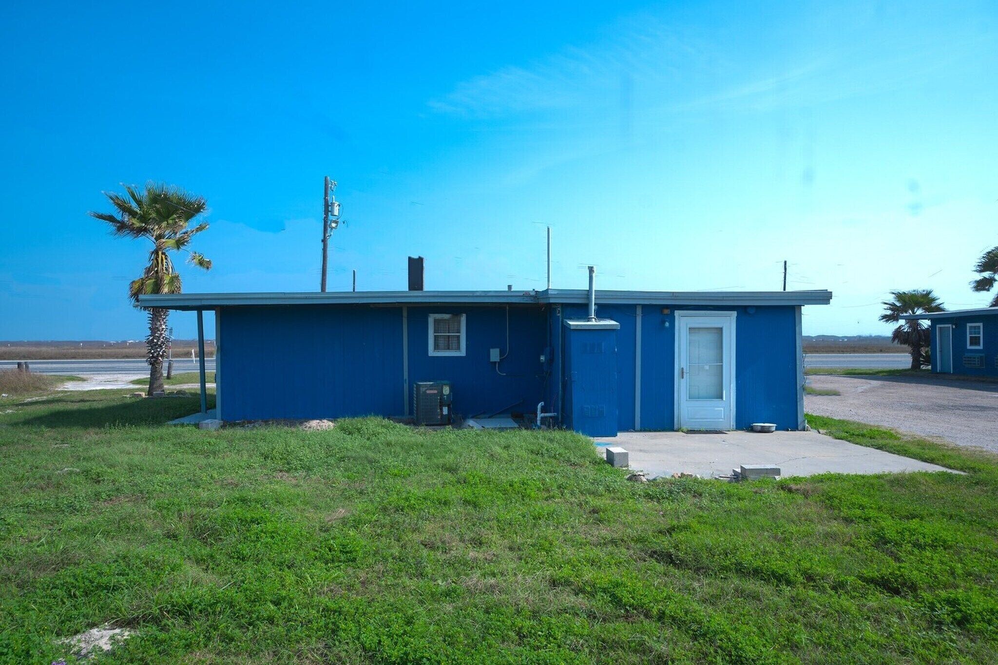 A small, single-story building with a flat roof, a door, and a small window.