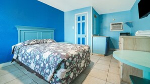 Une chambre à coucher avec un lit, un bureau, une chaise, une télévision et une porte.