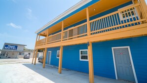 A motel with a blue exterior, a balcony, and a visible door marked with the number 20.