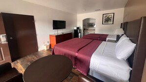 A hotel room with a bed, a TV, a desk, and a chair.