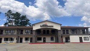 A two-story Budget Inn with a flat roof, a central entrance, and a fire lane marked on the ground.