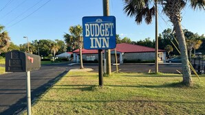 A sign for Budget Inn, a U.S. Post Office, and a mailbox.