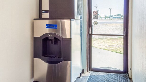 A commercial ice dispenser and a door with a no-smoking sign.