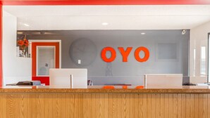 A reception desk with a clock and the word 'OYO' on the wall.