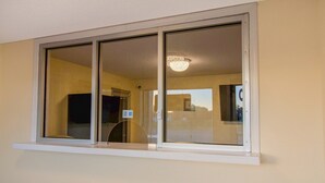 Una habitación con un ventanal grande, una lámpara de techo y una puerta.