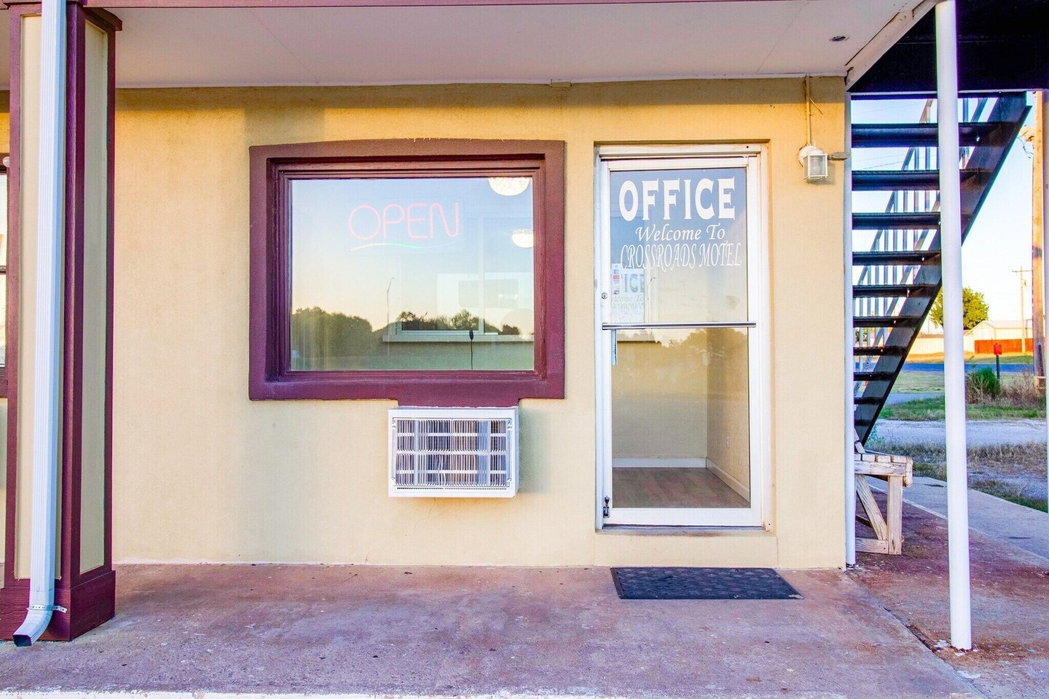 Een gebouw met een 'OPEN' bord, een 'OFFICE' bord en een raam met uitzicht.