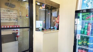 A vending machine with Mountain Dew and other sodas, a window with a sign, and a parking sign. - Queen Bed | Smoking | Sparta, GA (Sparta, GA)