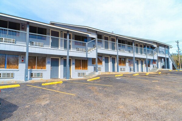 Un motel de varios pisos, con balcones y estacionamiento.