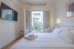 A hotel room with a bed, a small table with a bowl, a framed picture on the wall, and a balcony with a railing. - Syntagma Gem 2 Steps from Syntagma Square (Athina)
