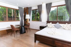 A bedroom with a large bed, a desk, a chair, and a window with curtains. - The Glens Tagaytay (Tagaytay)