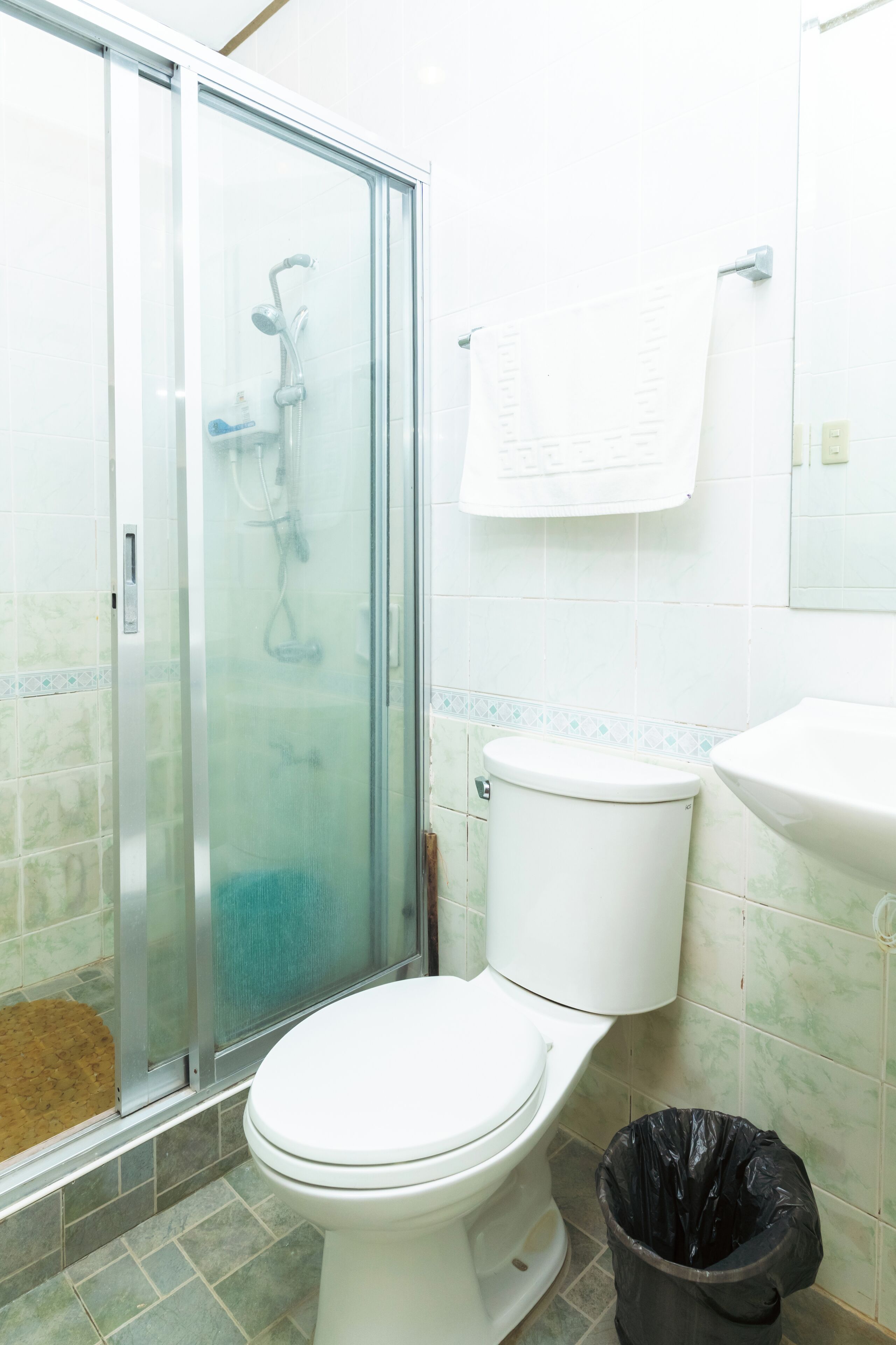 Un baño con ducha de vidrio, inodoro y lavamanos.