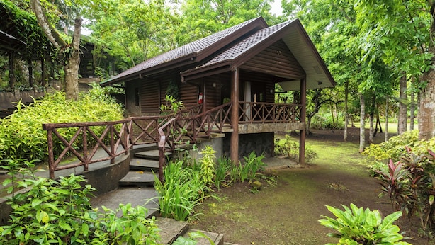 A wooden cabin with a porch and a wooden staircase leading to it. - The Glens Tagaytay (Tagaytay)