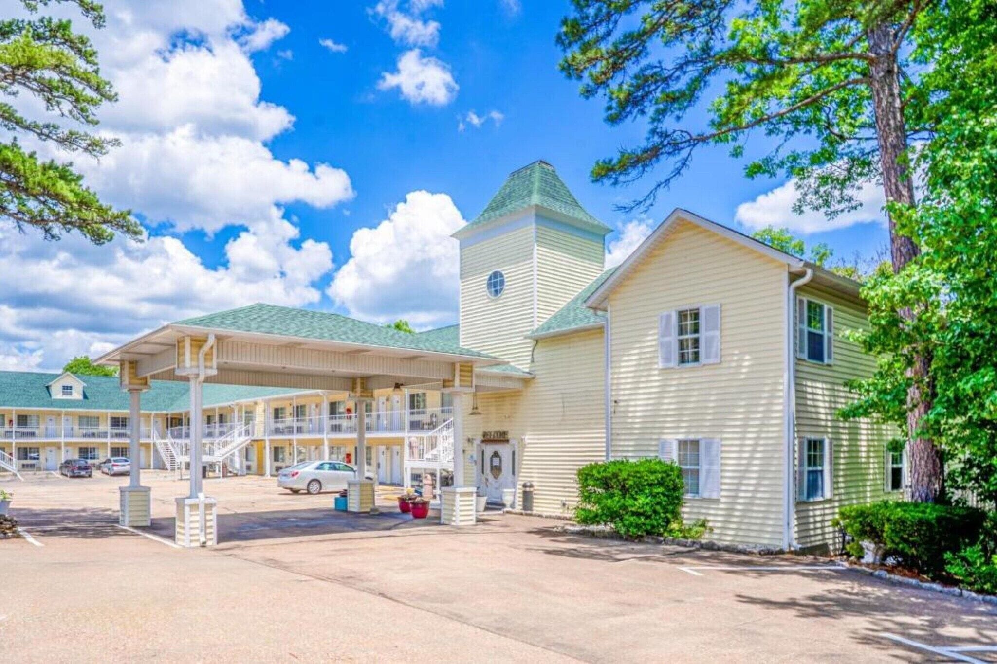 Un motel doté d’un parking couvert, d’une tour centrale et d’un bâtiment d’un seul étage.