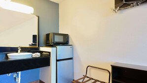 A compact bathroom with a sink, mirror, microwave, and a small refrigerator. - King Bed|Non Smoking (Valdosta GA)