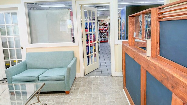 A room with a sofa, a wooden bench, and a glass table. - 2 Full Beds Non-Smoking (Valdosta GA)