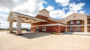 A building with a gas station, a covered parking area, and a two-story structure with balconies.