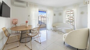 Ein modernes Wohnzimmer mit Essbereich, einer Couch und einem an der Wand befestigten Fernseher.