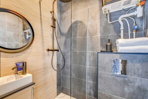 A modern bathroom with a shower, a sink, and a mirror. - Charming Studio Apartment - AC- 2P - Nation (Paris)