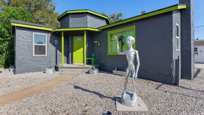 A modern building with a unique architectural design, including a green door and windows, and a sculpture in front. - Alien-Crash-Site-Themed Retreat in Roswell (Roswell)