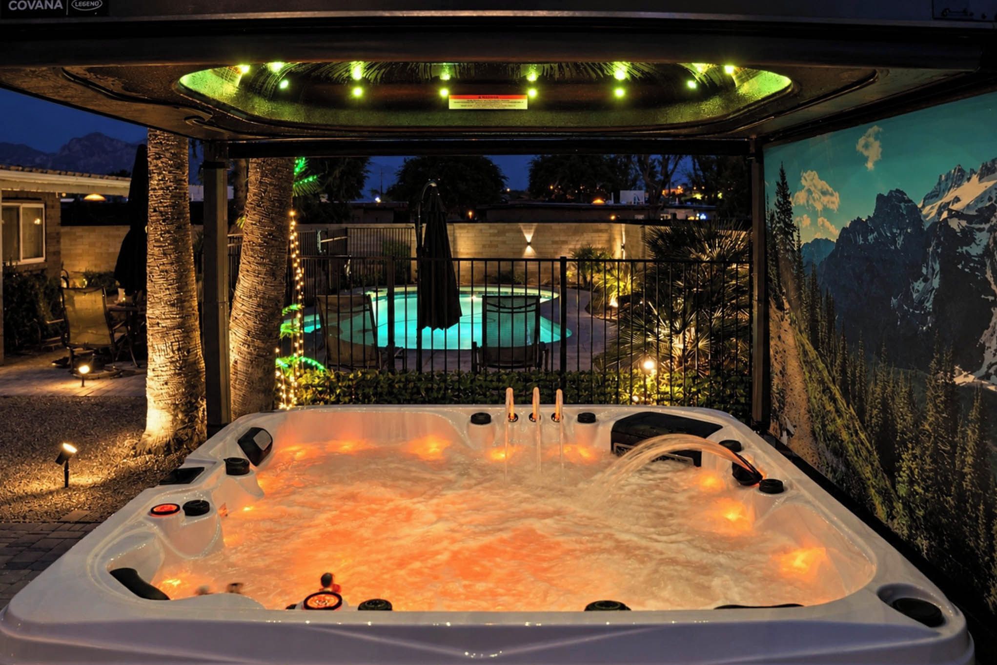 Un bain à remous avec vue sur une piscine et, au loin, sur des montagnes.