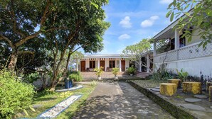 A pathway leading to a building with a porch, surrounded by greenery and trees. - Luxury Deluxe DBL Escape W/ Free WiFi and Parking (Yogyakarta)