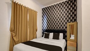 A hotel room with a bed, a headboard, a nightstand, a mirror, and curtains. - Luxury Deluxe DBL Escape W/ Free WiFi and Parking (Yogyakarta)